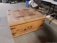 Rustic square trunk coffee table showing top and side with iron hinges and handles