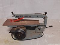 Photo of Delta 15 inch scroll saw showing side profile with motor and table visible.