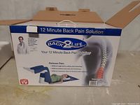 Closed box showing Back2Life 12 Minute Back Pain Solution branding and usage images.