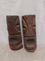 Two hand carved wooden totems side by side showing overall shape and condition