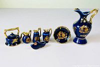 Complete set of seven cobalt blue Limoges porcelain miniatures including kettle, plate, pitchers, and shoe