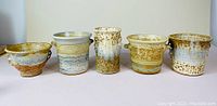 Five JP Star pottery planters arranged side-by-side showing size variation and glaze patterns