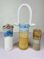 Front view of three JP Star pottery tall vases showing different shapes and glazes.