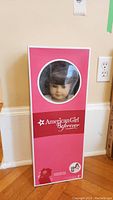 Boxed American Girl Samantha Parkington doll with visible face through circular window.