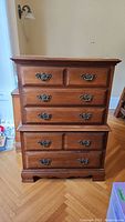 Front view of the Kroehler tall boy dresser showing all five drawers and metal handles clearly visible with wood grain finish.