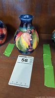 Front view of the 5 inch Moorcroft vase showing the colorful leaf and berry pattern in vibrant glazes.