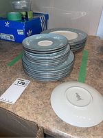 Stack of Royal Doulton Reflection plates and saucers showing the gray-blue floral rim pattern and white centers.