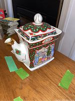 Square ceramic Sadler teapot decorated with a Christmas family scene by the fireplace and decorated tree. Lid and spout shown with gold accent details.