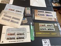 Photo showing a set of Canadian locomotive-themed stamps from 1984 within collector envelope labeled '100 Different Before 1953', and loose stamps in plastic bags.