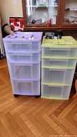 Two plastic storage drawer units side-by-side, one purple and one yellow-green, showing front and top drawer configurations.