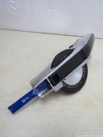 Manual label maker angled to show embossed character tape and chrome finish