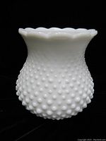Side view of vintage hobnail milk glass lampshade showing bulbous shape with scalloped top edge.
