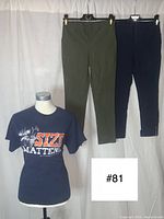Three women's clothing items displayed: two pairs of pants (olive green and black) hanging, and a navy blue T-shirt with 'Size Matters' graphic on a mannequin torso.