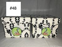 Front view of the two large rectangular storage boxes with removable lids, showing matching gothic Victorian black damask pattern on white and the circular decal of a zombie pin-up girl on brains on each box front.