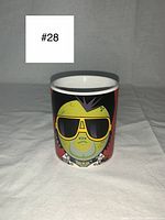 Front view of the ceramic coffee mug depicting a cartoon zombie Elvis Presley with yellow sunglasses on red background.