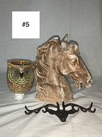 Photo showing the ceramic owl night light warmer, the brown and cream horse head candle with wax drips, and the black metal deer hook with multiple hooks.