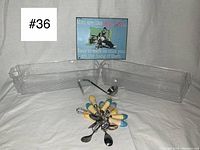 Collection displayed showing spoons fanned out along with two clear plastic bins, ceramic ladle, and tin sign propped in background.