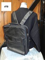 Back view of the vintage black leather backpack showing adjustable leather shoulder straps and zippered compartments.