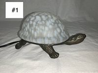 Photo of the vintage turtle table lamp showing the glass shell and metal turtle body from a side angle.