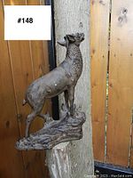 Side view of the vintage metal deer door stopper showing the full profile and textured detailing on the base and deer.