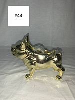 Side profile of gold metal French Bulldog tape dispenser showing tape roll in place.