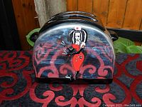 Front view of the vintage toaster cookie jar with gothic nurse artwork, showing chrome finish and nurse holding syringe in red uniform.