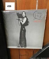 Front of album cover featuring Cher holding a black cat, in plastic sleeve