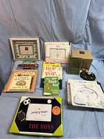 Photo of 5 children's picture frames and 7 children's books arranged on a cloth background.