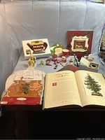 Full lot showing all items including teapot, apron, chef hat, photo album, candles, ornaments, and book on a table