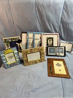 Photo showing overall lot of varied picture frames in different styles, sizes, and colors, mostly new with some in packaging.