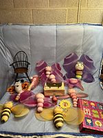 Full lot photo showing plush butterflies, dolls chair, photo album, small wooden box, and additional small toys and accessories on blue backdrop.