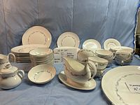 View of entire Coronet pattern set arranged on cloth showing plates, bowls, cups, and serving pieces, highlighting condition and quantity.