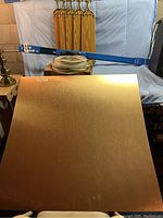 Copper-colored aluminum sheet with reflective surface and fan blades behind it