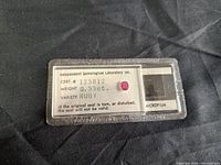 Front of plastic certificate card showing ruby gemstone, certification number 125812, weight 0.55ct and variety ruby text.