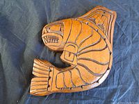 Top view of the wooden killer whale carving showing incised details and medium brown wood surface.