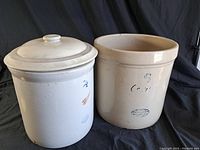 Two vintage ceramic crocks side by side, one with lid, one without