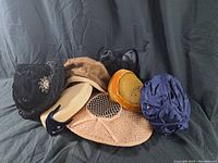 Six vintage hats grouped together showing variety of styles and colors.