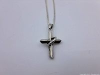 Front view of the cross pendant and chain with visible twisted ring detail.