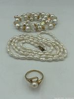 All three items shown: two pearl necklaces and one gold pearl ring.
