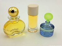 Three perfume miniature bottles: Sexual, Armani Mania, and blue bottle with green cap