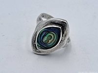 Close-up front view of vintage sterling silver ring featuring abalone shell in bezel setting showing the stone's iridescent colors and the silver's aged patina.