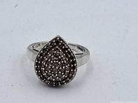 Front view of vintage teardrop-shaped sterling silver ring with champagne diamonds set in cluster pattern