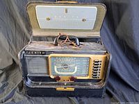 Full view of the Zenith radio in its protective carrying case with the lid open, showing the radio and handle.