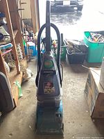 Front view of blue and gray upright Hoover SteamVac SpinScrub carpet cleaner with handle and branding.
