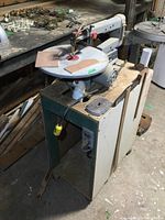 Side angle of Mastercraft 16 inch scroll saw on wheeled base showing overall setup with pedal and storage compartment.