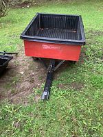 Front view of Agri-Fab trailer showing metal frame, plastic bed liner and front panel dent
