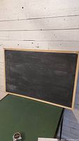 Front view of rectangular chalkboard with wooden frame showing overall condition.