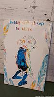 Front view of canvas art showing Dobby figure and quote with feather border