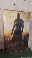 Front view of Gladiator movie poster on board showing the full image and text.