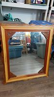 Front view showing the mirror with detailed wooden frame and reflections